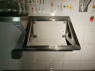 un évier en inox dans une cuisine aux murs carrelés de blanc