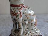 une figurine de chat posée sur une table blanche