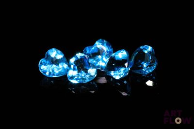 three blue diamonds on a black surface with a black background