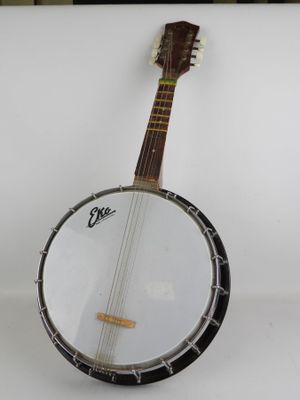 un gros plan d'un banjo posé sur une surface blanche