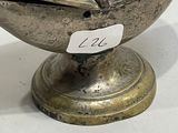 a small metal bowl with a lid on a table