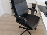 une chaise de bureau noire assise devant un bureau blanc