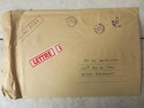 an envelope with a stamp on it sitting on a tile floor