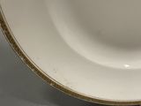 a white plate with gold trim on it on a table