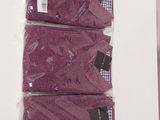 three pairs of purple shirts sitting on top of a white table
