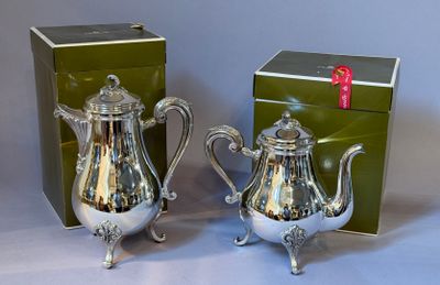 pair of silver plated teapots with matching box on table