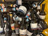 many bottles of beer sitting in a bin on the floor