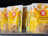 three bags of cereal sit on top of a shelf in a store