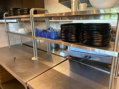 de nombreuses assiettes et bols posés sur une étagère en métal dans la cuisine