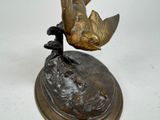 a statue of a bird sitting on top of a base