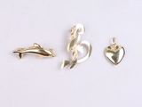three pieces of gold jewelry on a white surface