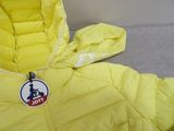 une veste jaune munie d'une étiquette, posée sur un canapé