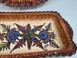 two decorative dishes sitting on a white table