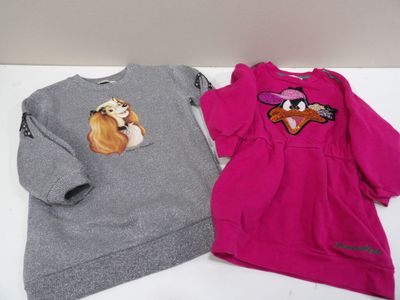 une paire de sweats pour enfants avec des chiens imprimés dessus, posée sur une table