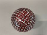 a red and white glass ball sitting on a white surface
