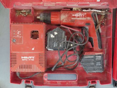 une boîte à outils rouge contenant une perceuse et d'autres outils
