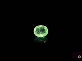 a close up of a glowing green ball on a black surface