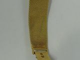 a close up of a gold watch on a white surface