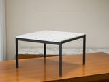 une petite table avec un plateau en marbre posée sur une table en bois