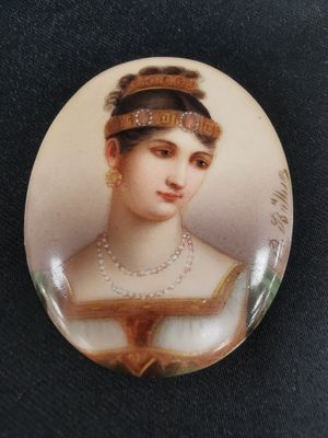 a close up of a button with a woman wearing pearls