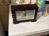 a clock sitting on top of a washing machine next to a washer