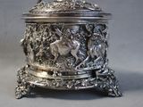 a silver box with a deer on it sitting on a table