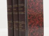 three books sitting on top of each other on a white surface