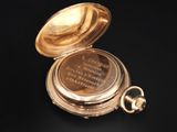 pocket watch on a black background with a quote on it
