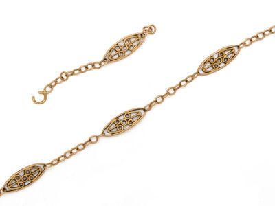 un gros plan sur un bracelet en or muni d'une chaîne