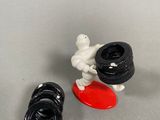 a toy figurine of a man on a snowboard next to a tire