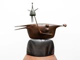 a sculpture of a woman sitting on top of a pot