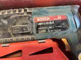 a close up of a corded drill with a red case