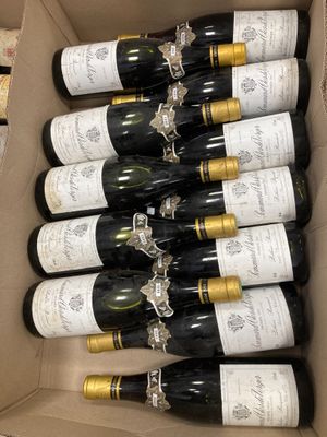 six bouteilles de vin dans un carton sur une table