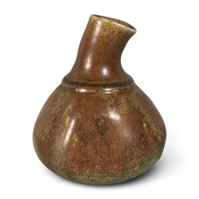 a brown vase that is sitting on a white surface