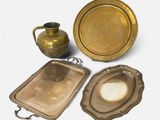 une assiette en or, un plateau et un pichet sur fond blanc
