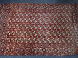 un tapis rouge à motifs posé sur un sol bleu