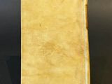 an old yellow book sitting on top of a black table