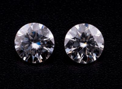 une paire de diamants ronds taille brillant sur un fond noir