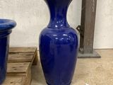 two blue vases sitting next to each other on a pallet