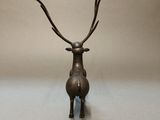 bronze sculpture of a deer with antlers on its head