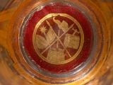 a close up of a glass with a red and gold emblem