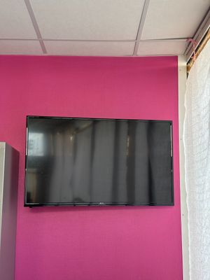 une télévision à écran plat accrochée à un mur rose dans une pièce