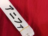 a white belt with black writing on it on a red cloth