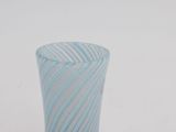 a blue and white striped glass vase on a white surface