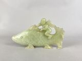 une figurine représentant un homme chevauchant un poisson