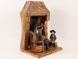 a figurine of a man and a woman in front of a hut