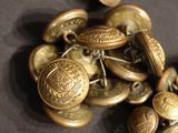 a pile of old brass buttons on a table