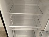 an open refrigerator that is sitting on a wooden floor