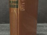 an old book sitting on top of a table next to a black wall