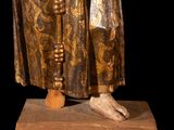 an old statue of a man in a robe holding a cane